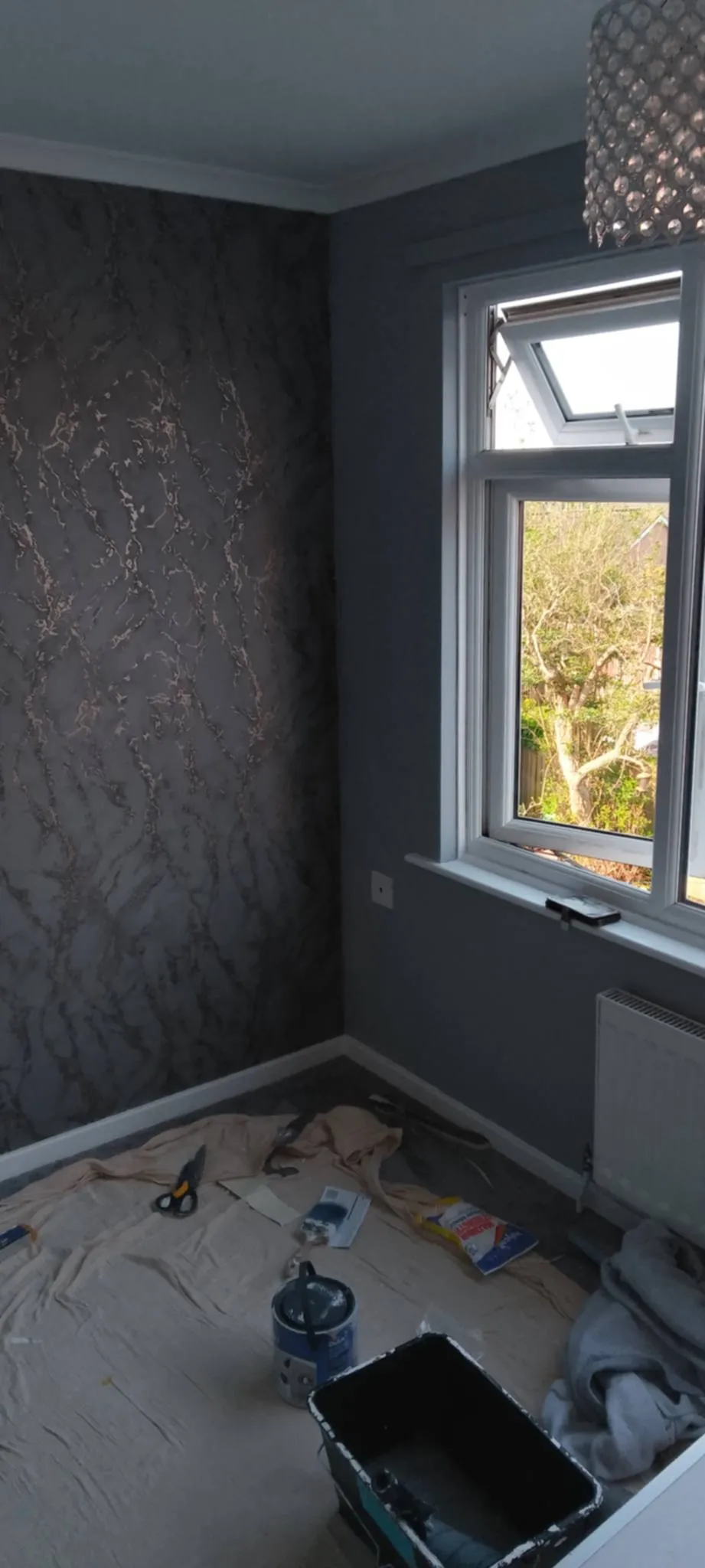 a bedroom with grey wallpapering and grey walls