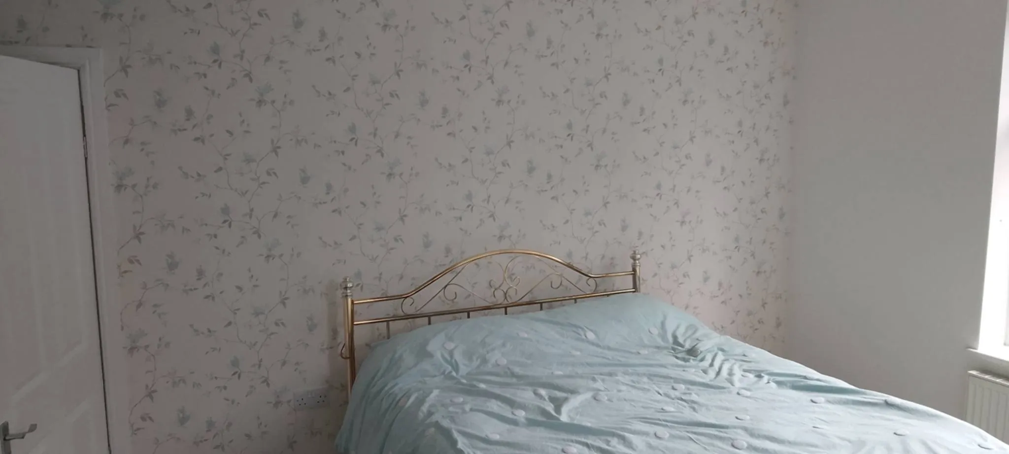 a wallpapered beedroom